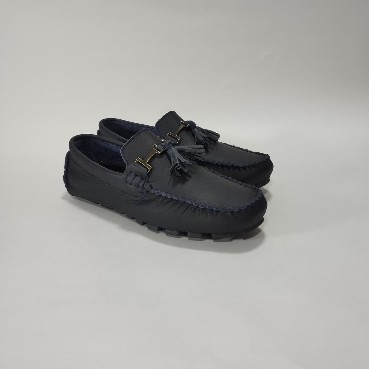 Mocasín de cuero azul con detalle metálico, vista tres cuartos