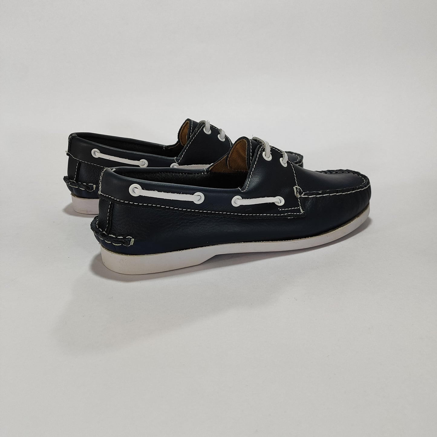 Par de náuticos de cuero azul con suela clara, vista lateral