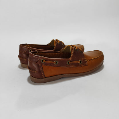 Par de náuticos de cuero miel con herraje y costuras, vista lateral