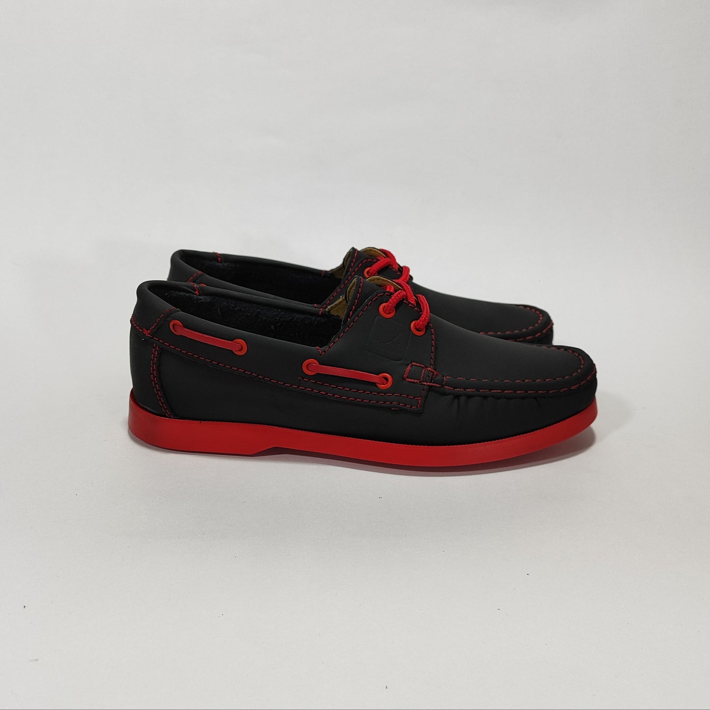 Zapato apache negro con suela roja, vista lateral