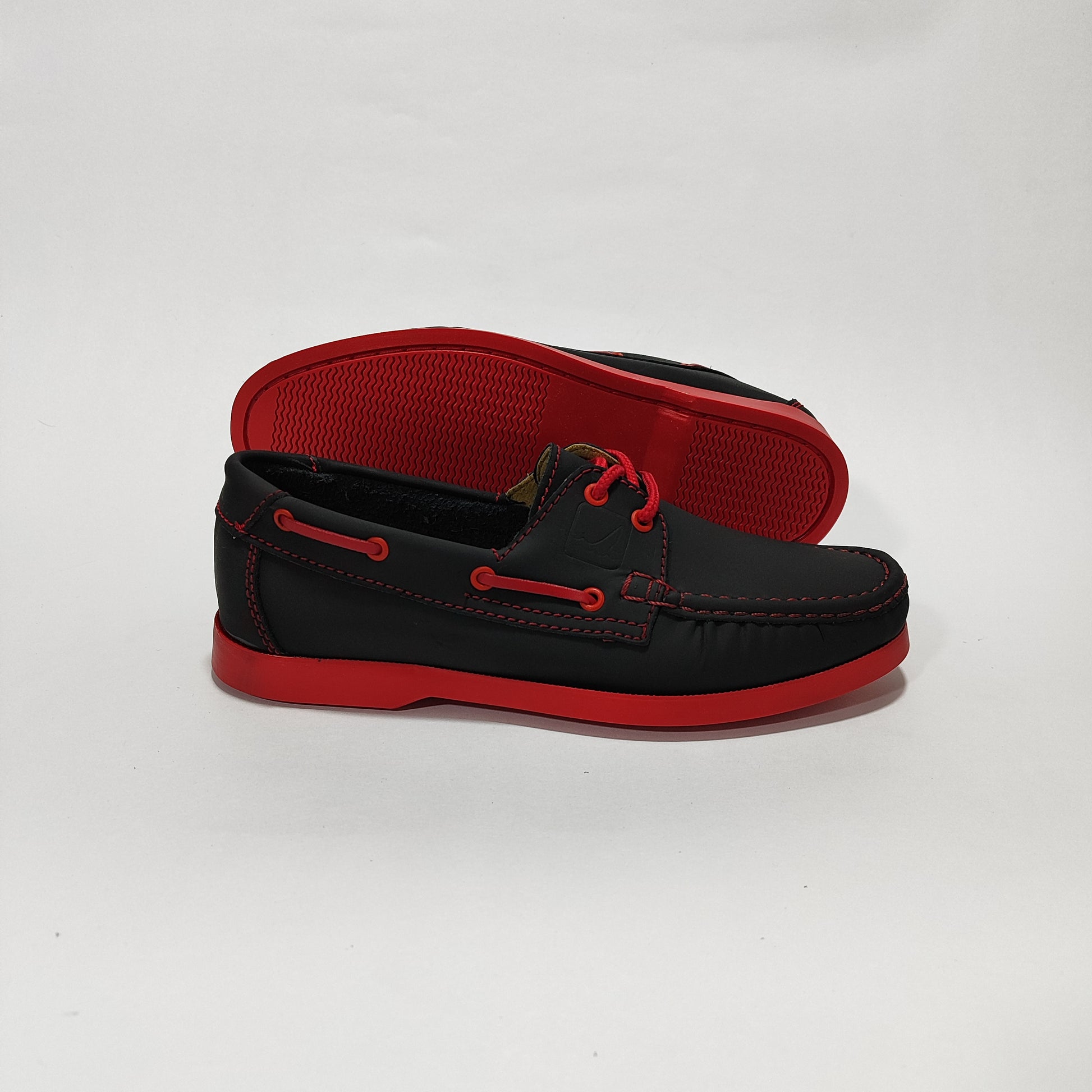 Par de zapatos apache negros con detalles rojos, vista lateral opuesta