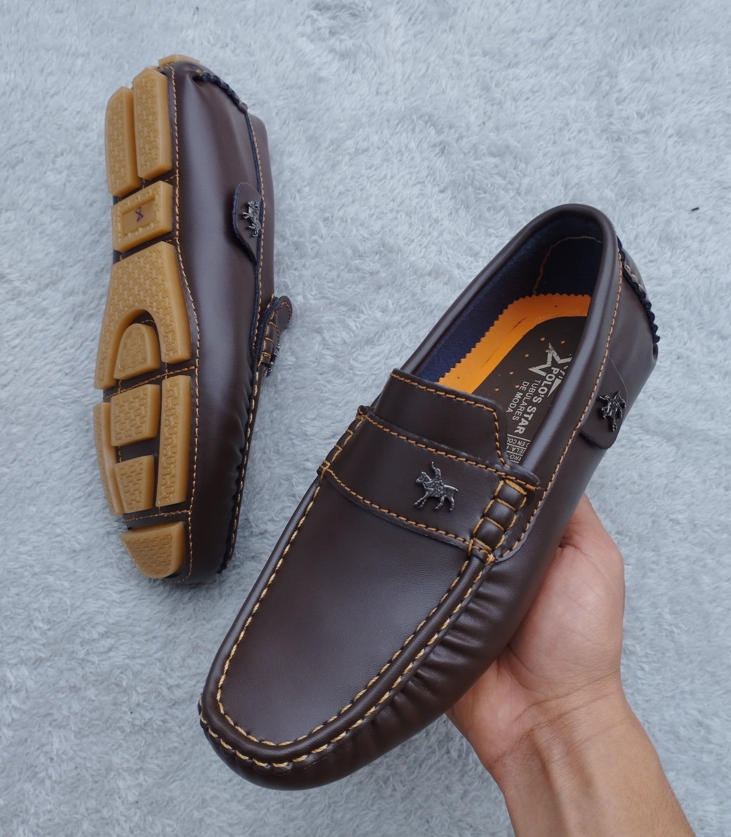 Mocasín café brillante con antifaz decorativo y costuras claras, vista tres cuartos